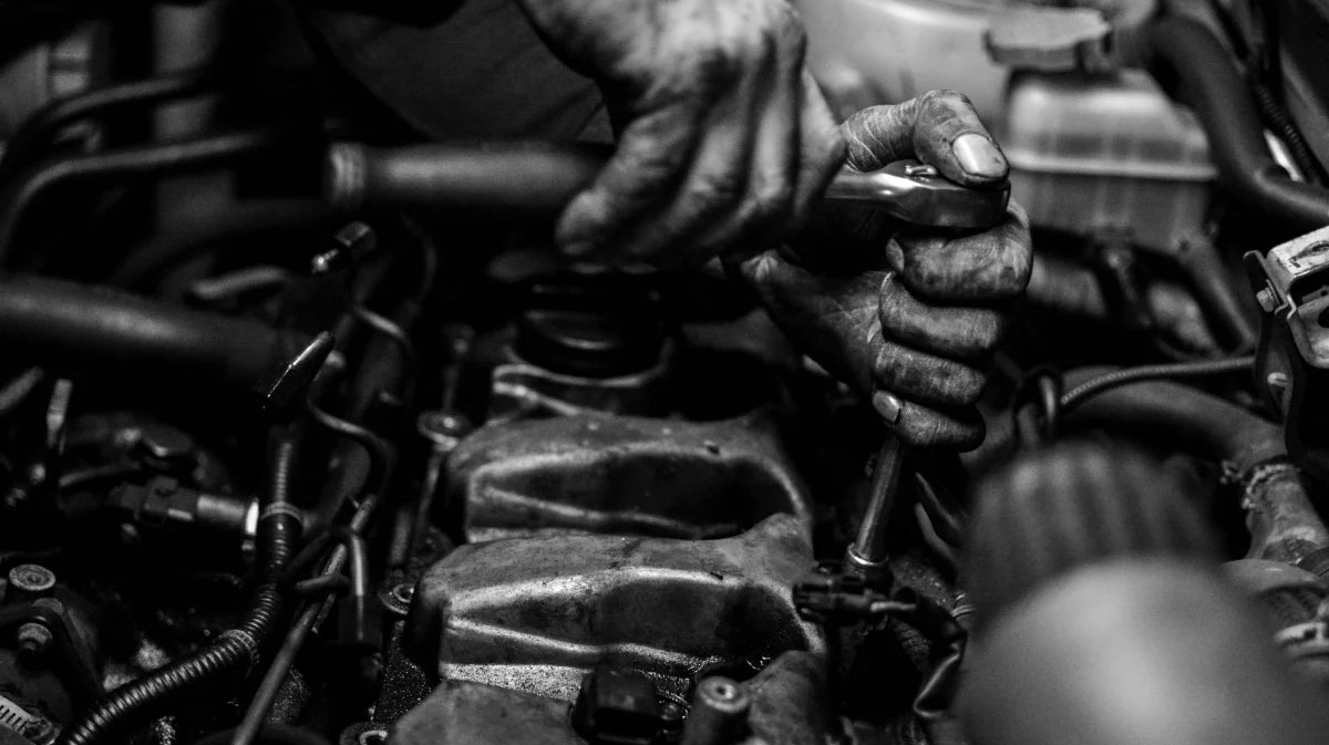 Close-up of hands working on a mechanical engine